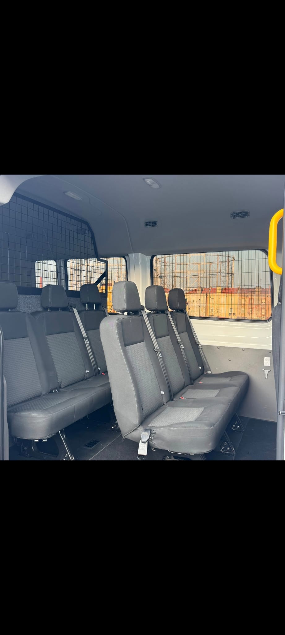 Interior do Ford Transit com bancos em tecido para transporte de equipa.